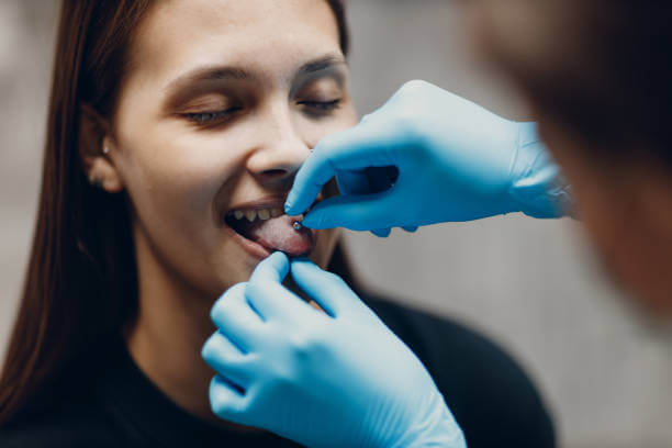 Young woman doing tonque piercing at beauty studio salon